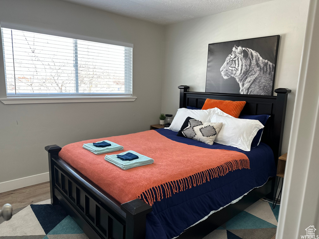 Bedroom featuring a textured ceiling and hardwood / wood-style flooring