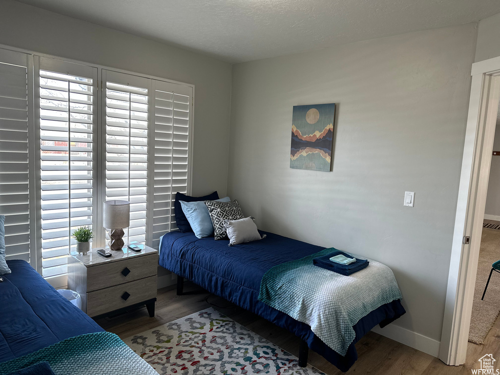 Bedroom with multiple windows and light wood-type flooring