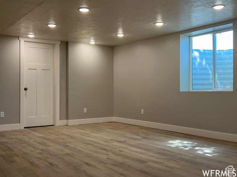 Unfurnished room featuring light wood-type flooring and a textured ceiling