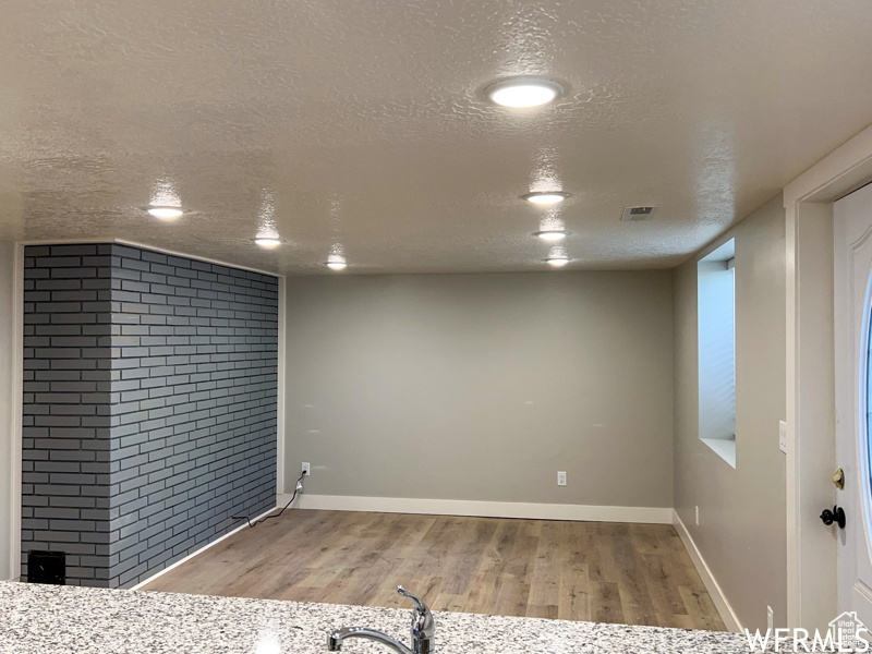 Interior space with wood-type flooring and a textured ceiling