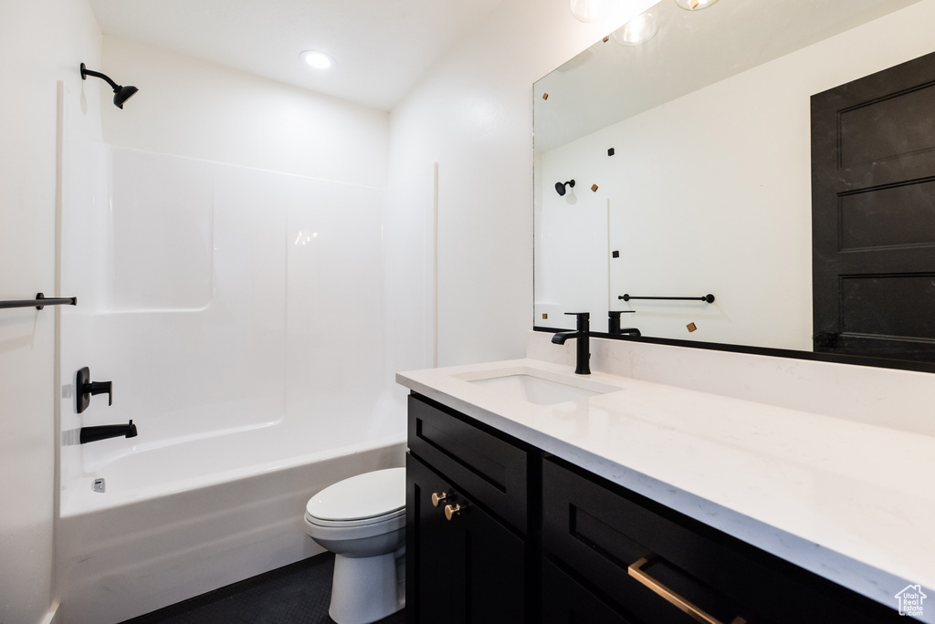 Full bathroom featuring toilet, vanity with extensive cabinet space, and shower / bathtub combination