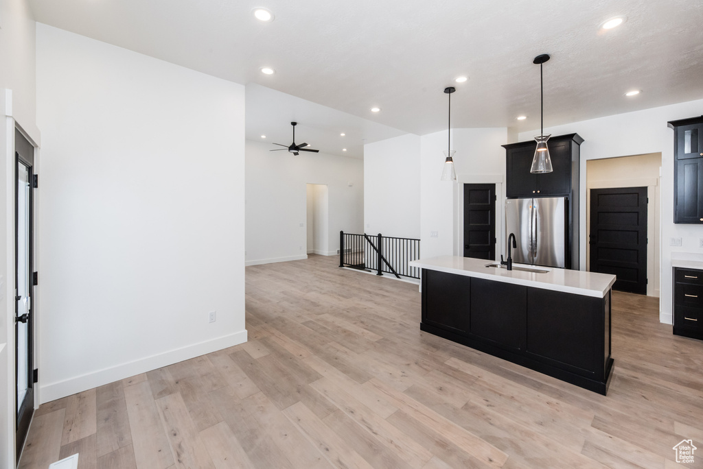 Kitchen featuring pendant lighting, stainless steel fridge, light hardwood / wood-style flooring, and ceiling fan