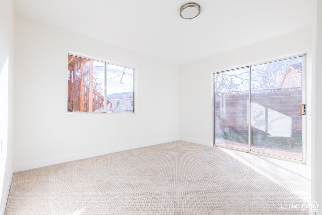 Carpeted empty room featuring a wealth of natural light