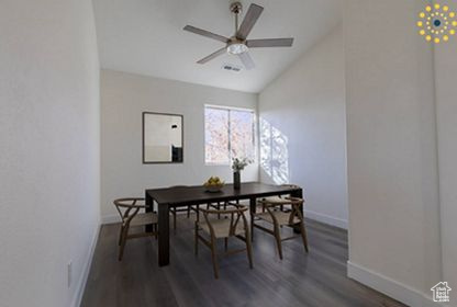 Dining room with dark hardwood / wood-style floors, ceiling fan, and lofted ceiling