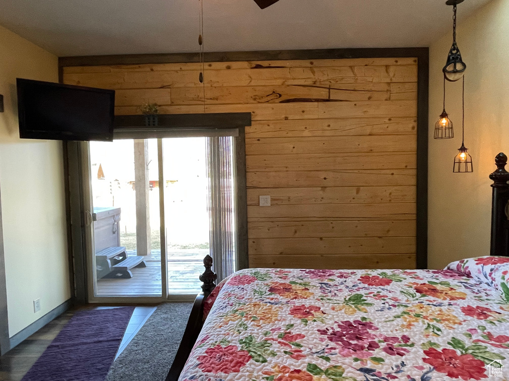Bedroom featuring wooden walls and access to outside