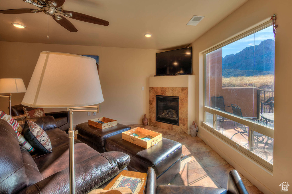 Living room with a tiled fireplace, ceiling fan, and a mountain view