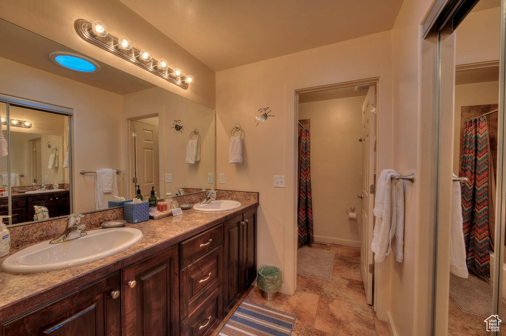 Bathroom with dual sinks, tile floors, and oversized vanity
