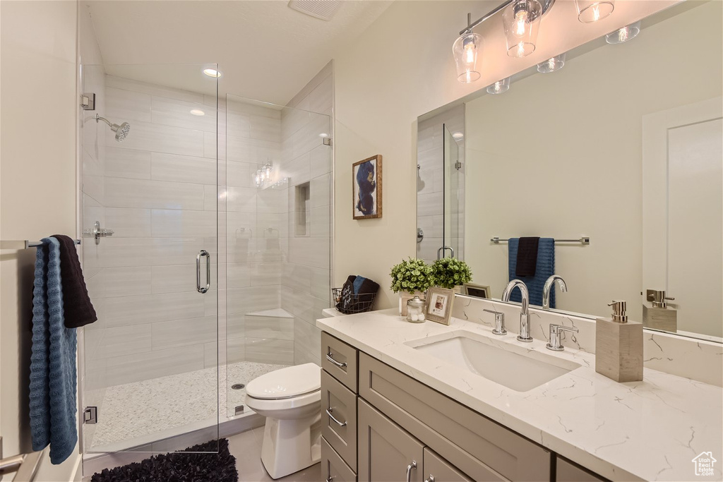 Bathroom featuring walk in shower, toilet, tile flooring, and oversized vanity
