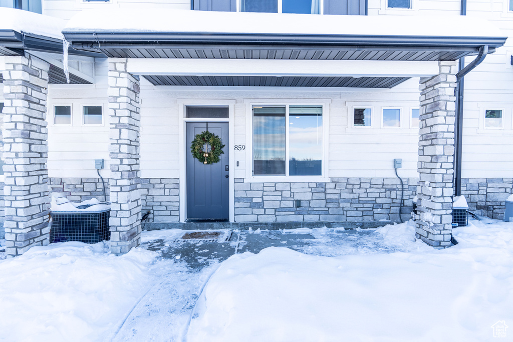 Snow covered property entrance featuring central AC