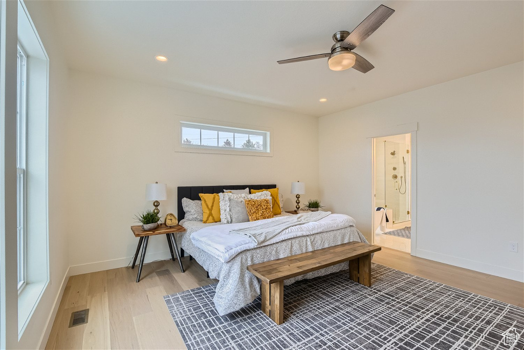 Bedroom with wood-type flooring, ensuite bath, and ceiling fan