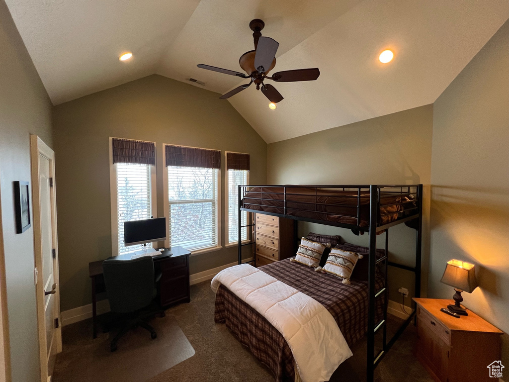 Bedroom with ceiling fan, dark colored carpet, and lofted ceiling