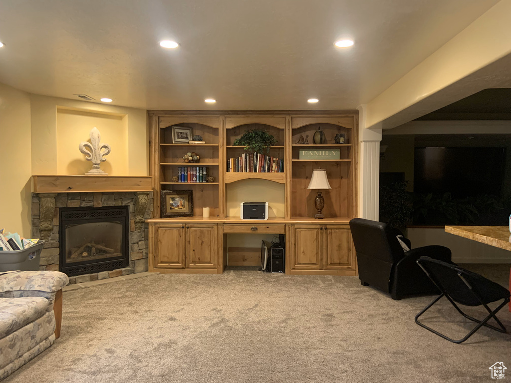Carpeted office space featuring built in features and a stone fireplace