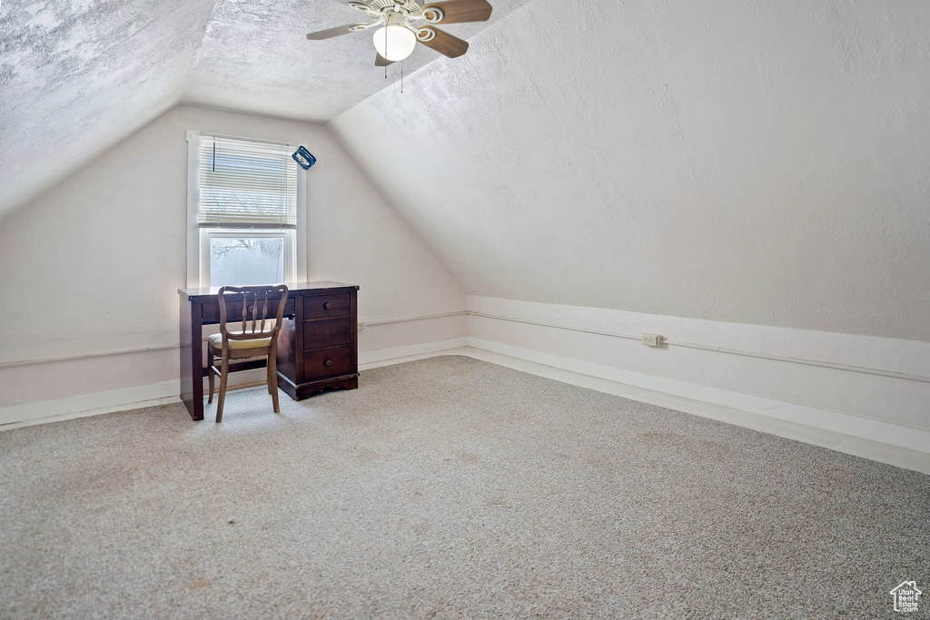 Bonus room with lofted ceiling, light carpet, a textured ceiling, and ceiling fan