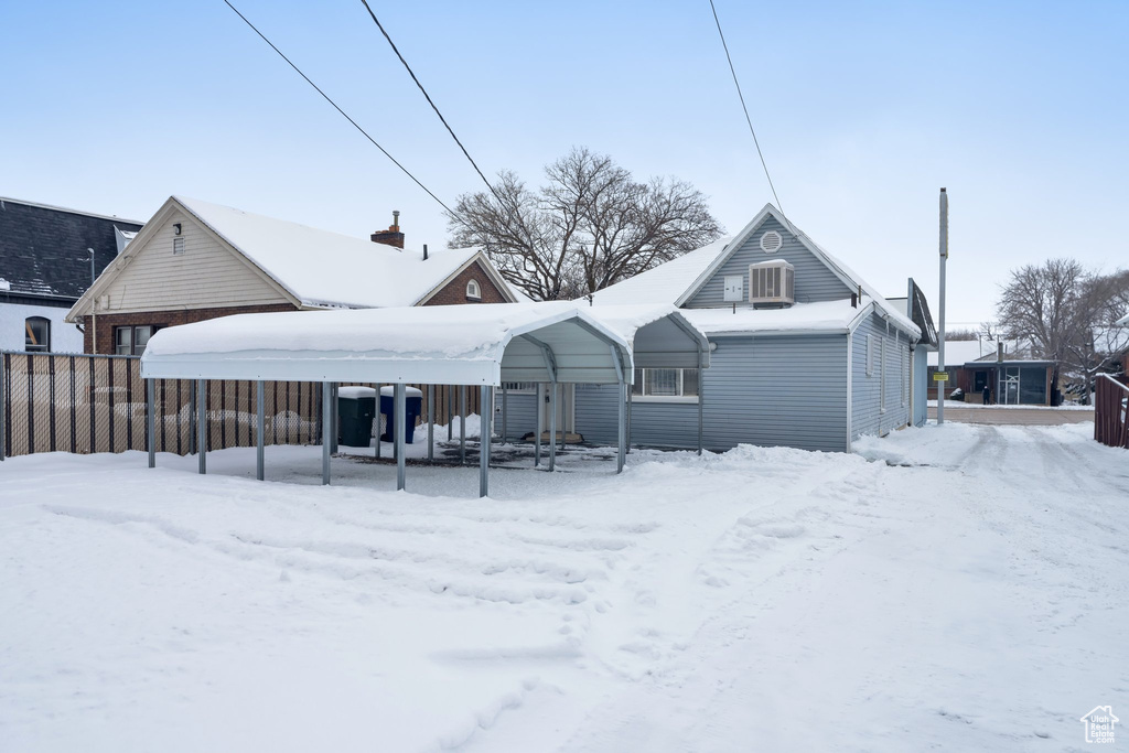 Snow covered property with a carport