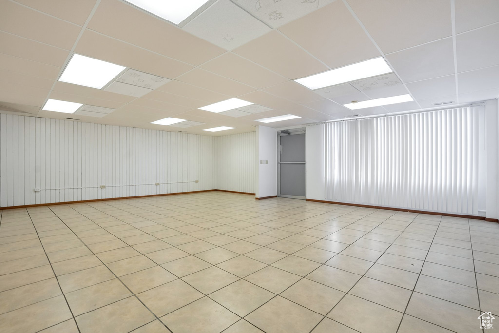 Tiled empty room featuring a paneled ceiling