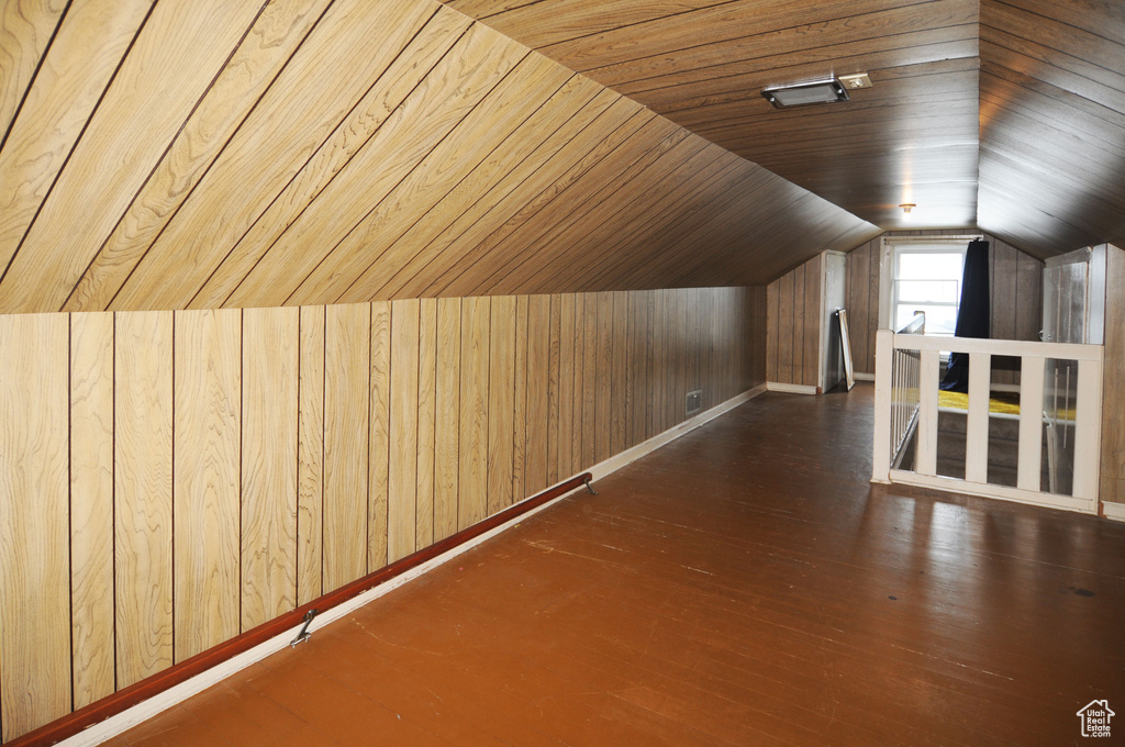 Additional living space with wood ceiling, vaulted ceiling, wood walls, and dark hardwood / wood-style flooring
