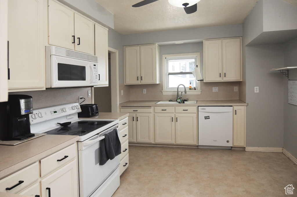 Kitchen featuring sink, white appliances, light tile flooring, and ceiling fan