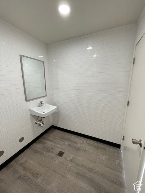 Bathroom featuring sink, tile walls, and hardwood / wood-style flooring