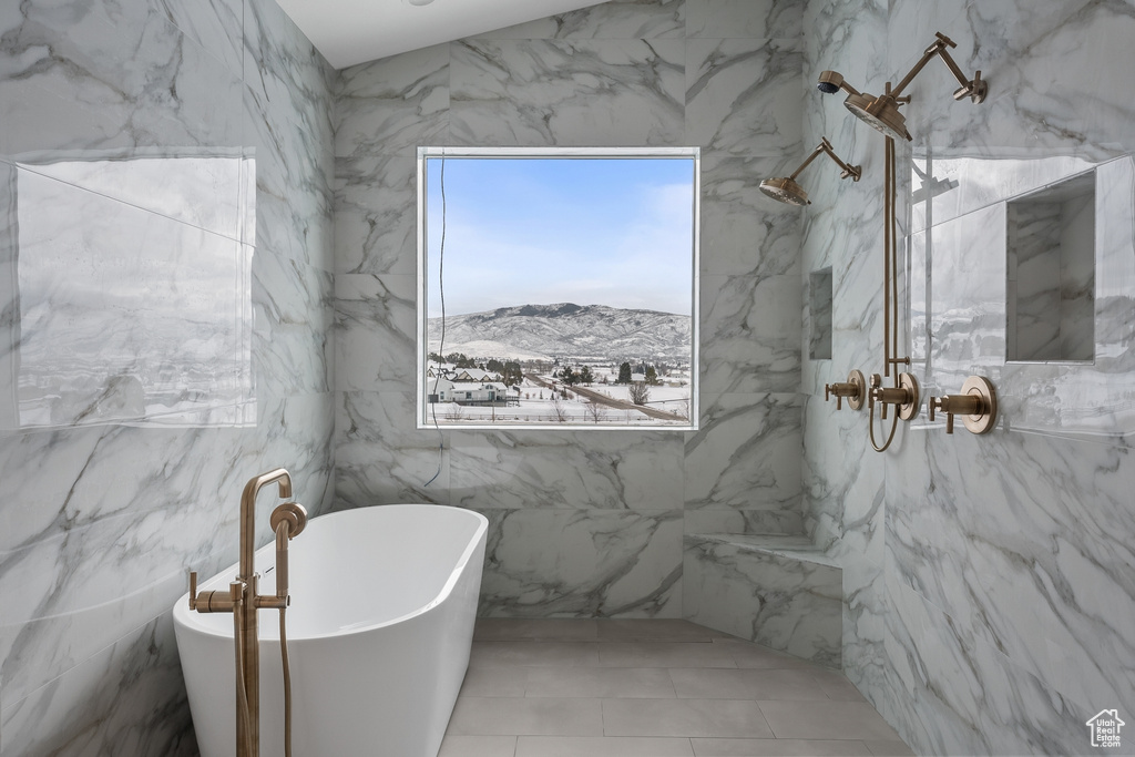Bathroom featuring separate shower and tub, tile flooring, tile walls, and a mountain view