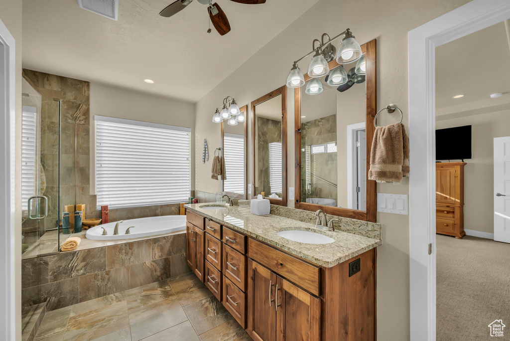 Bathroom featuring tile floors, double sink vanity, plus walk in shower, and ceiling fan