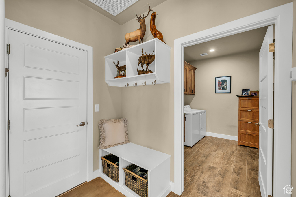 Mudroom with independent washer and dryer and light hardwood / wood-style floors