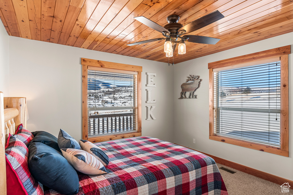 Carpeted bedroom with wood ceiling and ceiling fan