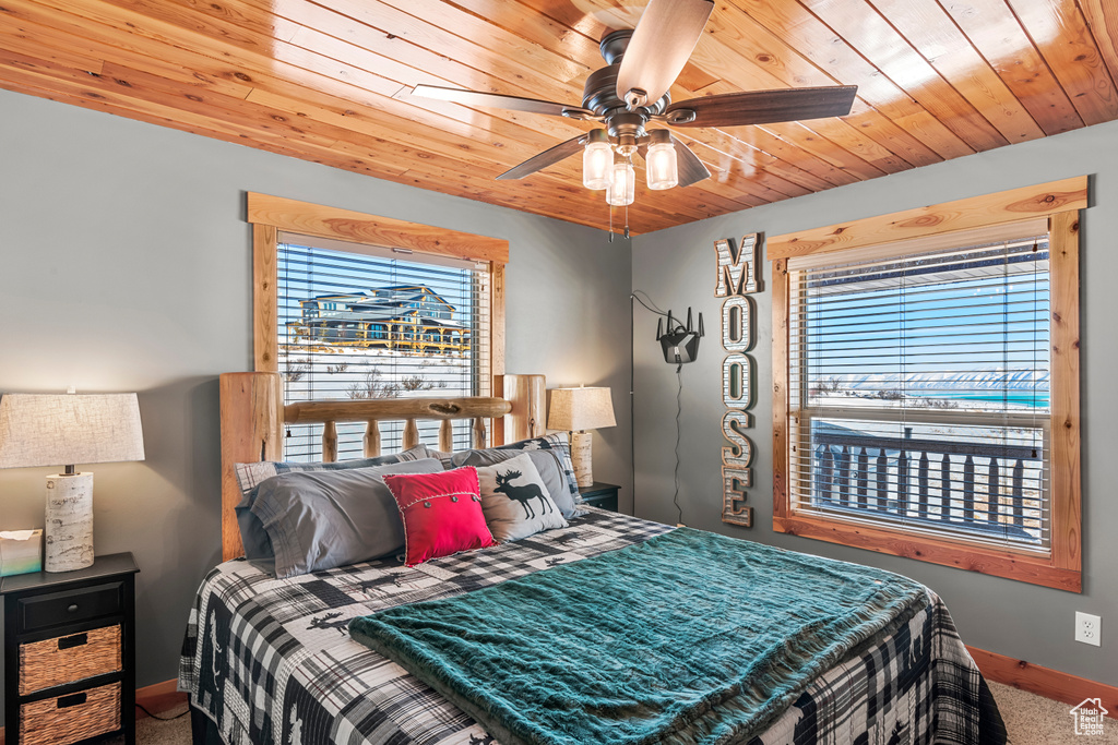 Bedroom with wooden ceiling, carpet floors, and ceiling fan