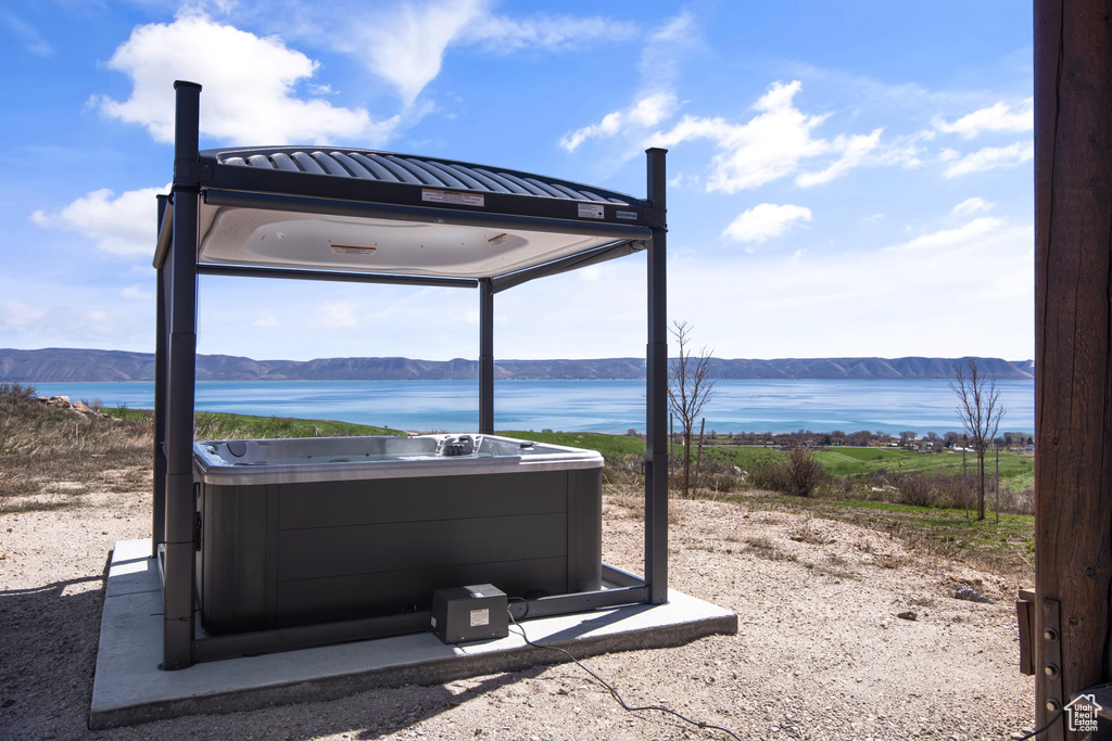 Exterior space with a water view and a hot tub