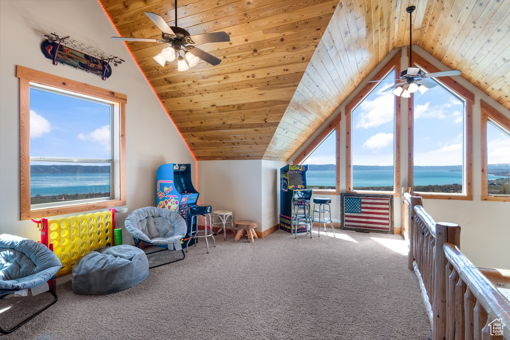 Rec room with a healthy amount of sunlight, lofted ceiling, a water view, and wooden ceiling