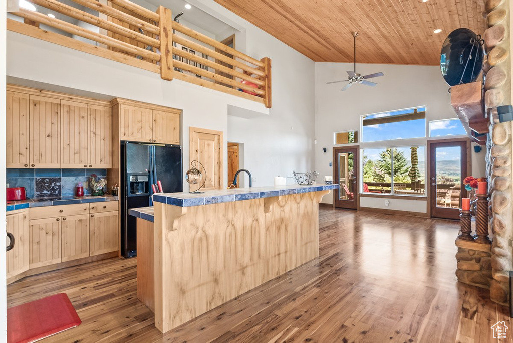 Kitchen featuring ceiling fan, tasteful backsplash, dark hardwood / wood-style flooring, wood ceiling, and high vaulted ceiling