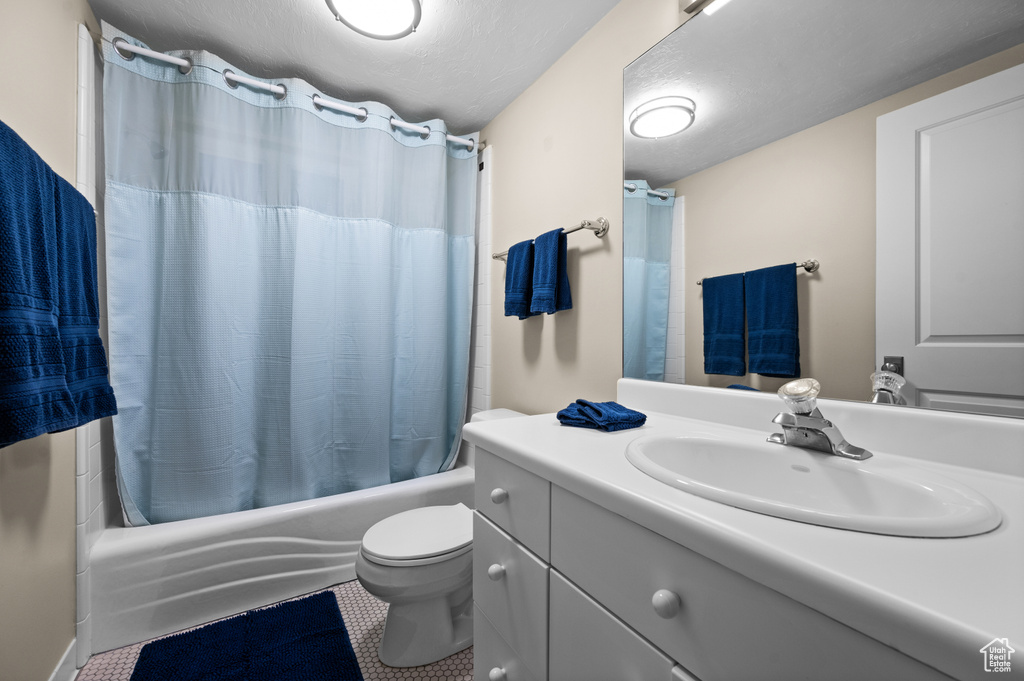 Full bathroom featuring shower / tub combo with curtain, toilet, tile flooring, and vanity