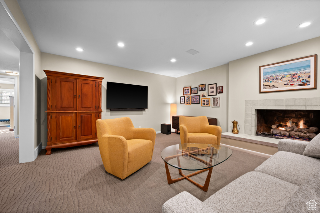 Carpeted living room featuring a tiled fireplace