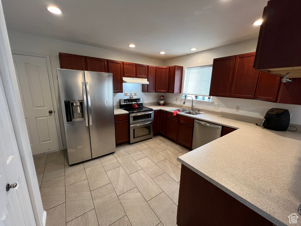 Kitchen featuring sink, stainless steel appliances, and light tile floors