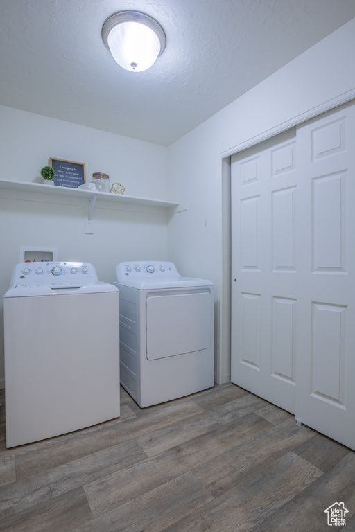 Washroom featuring wood-type flooring, separate washer and dryer, and washer hookup