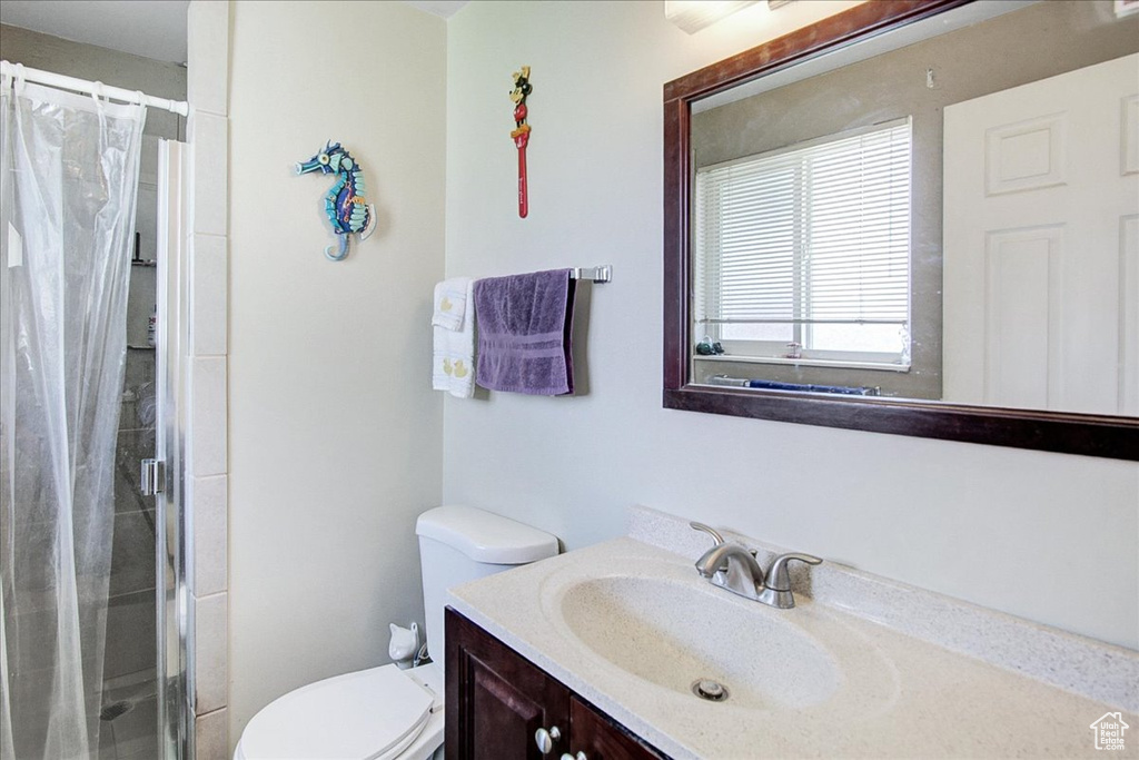 Bathroom with curtained shower, oversized vanity, and toilet