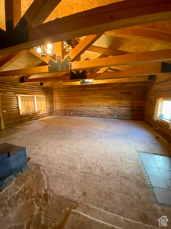 Interior space with carpet floors and lofted ceiling with beams