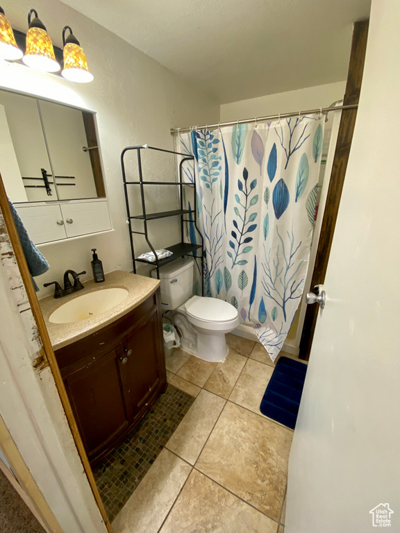 Bathroom with oversized vanity, toilet, and tile flooring