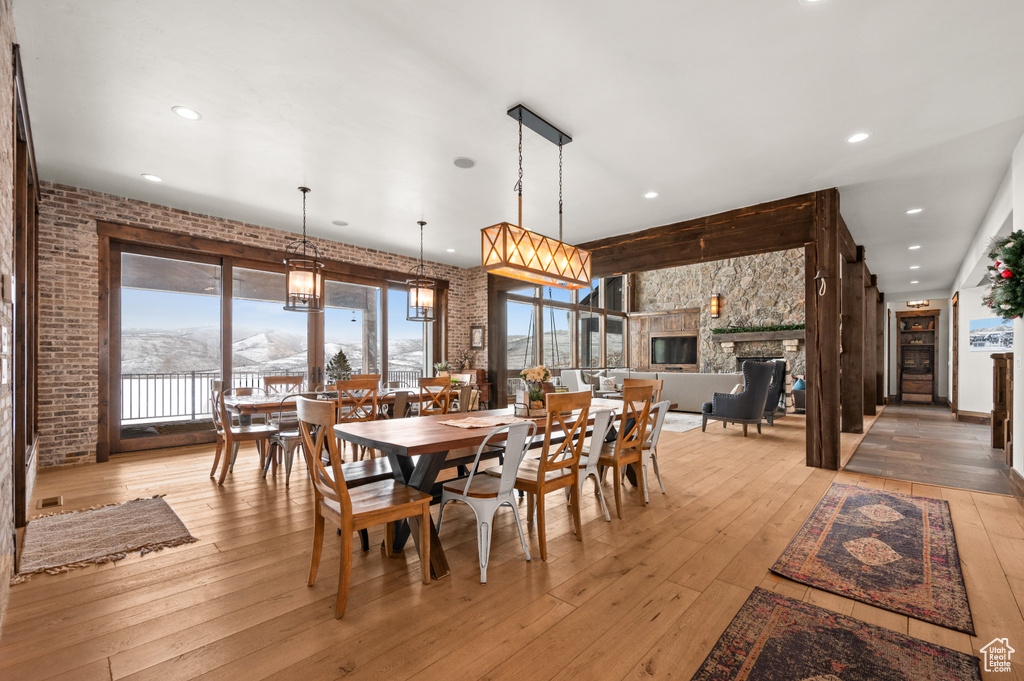 Dining area featuring a notable chandelier, light hardwood / wood-style floors, and a fireplace