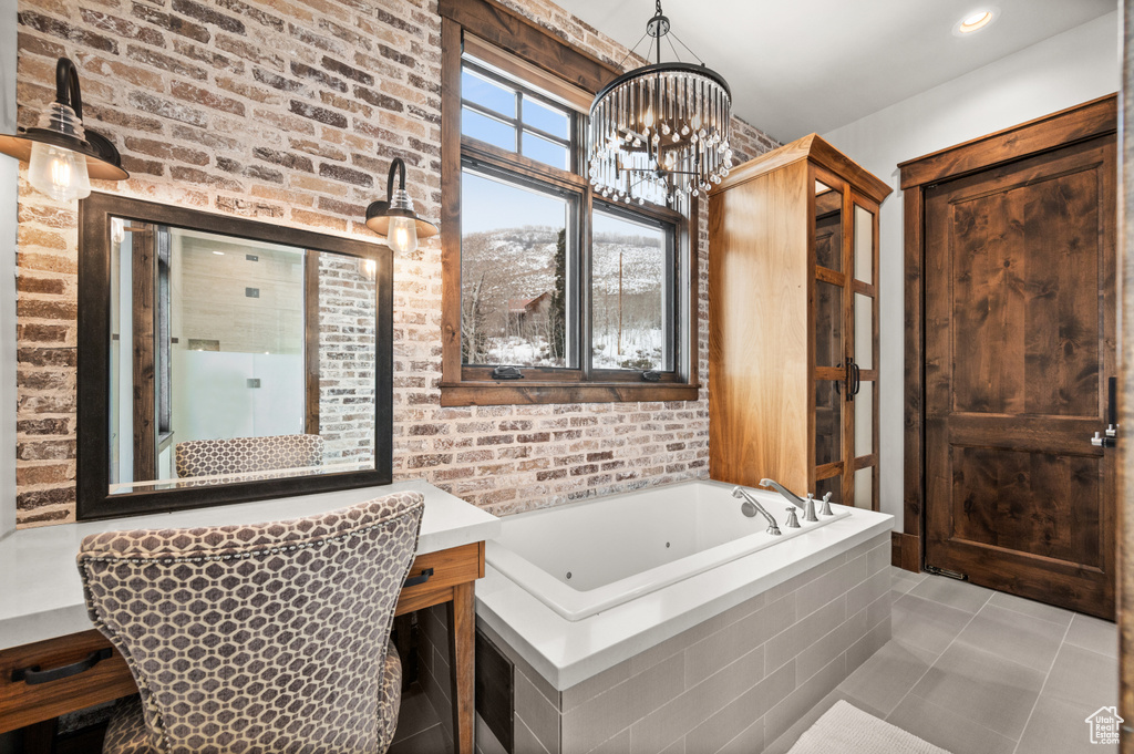 Bathroom featuring plus walk in shower, a chandelier, tile flooring, and brick wall