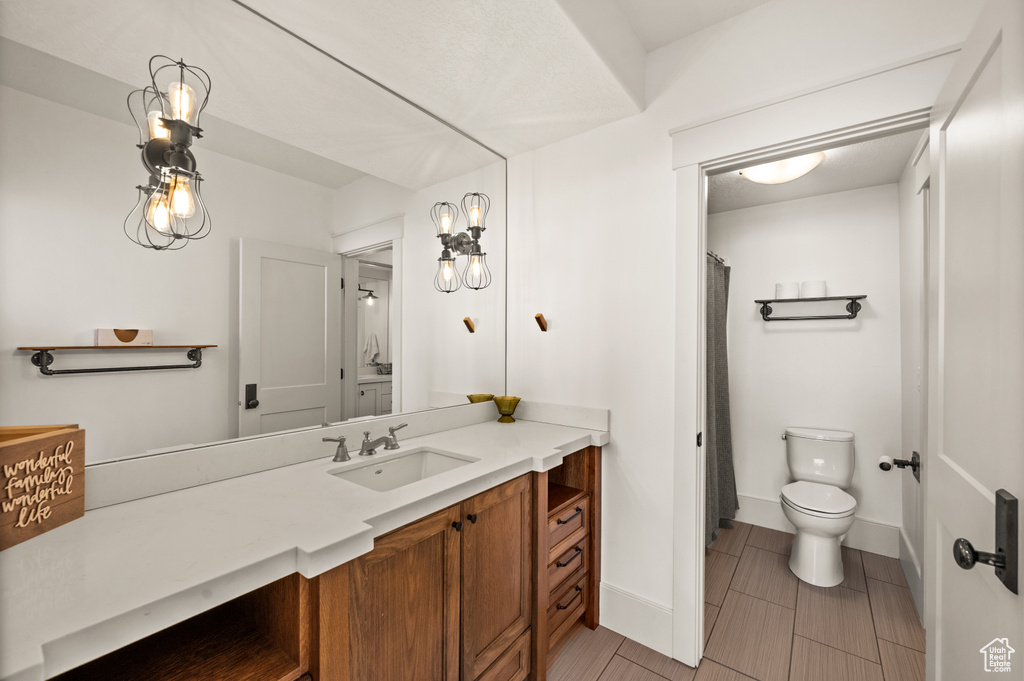 Bathroom with tile flooring, toilet, and large vanity
