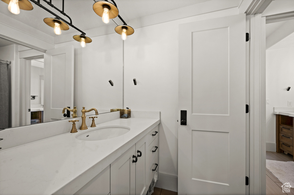 Bathroom with large vanity and hardwood / wood-style floors
