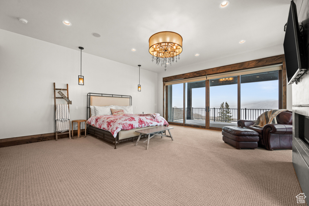 Carpeted bedroom with a chandelier and access to exterior