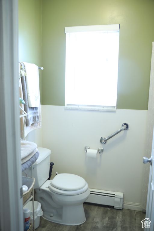 Bathroom with wood-type flooring, toilet, and a baseboard radiator