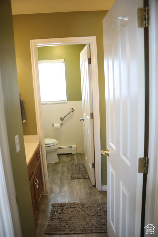 Bathroom featuring tile floors, a baseboard heating unit, toilet, and vanity