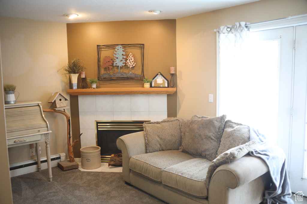 Living room with carpet, a baseboard radiator, and a tile fireplace
