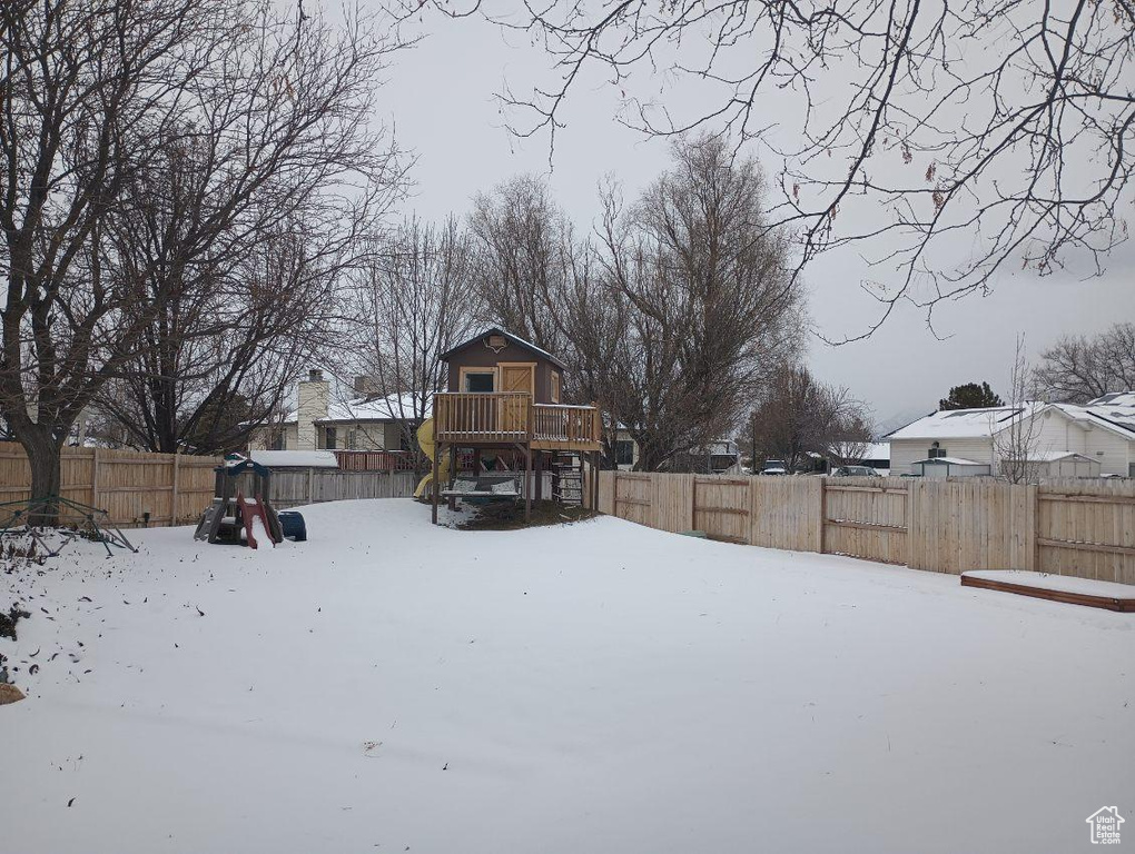 Snowy yard featuring a deck