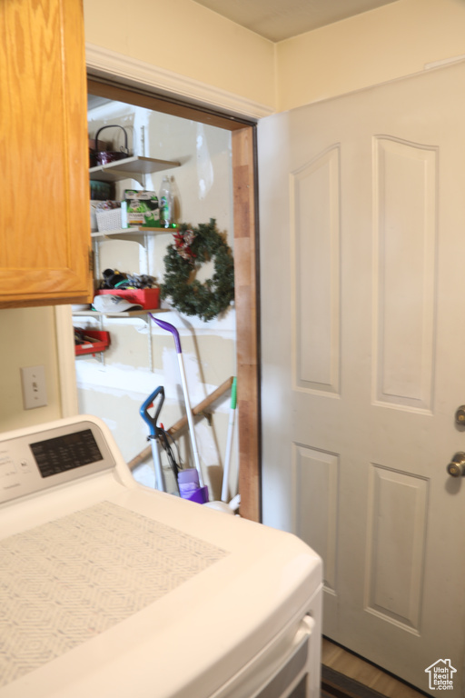 Clothes washing area featuring cabinets and washer / clothes dryer