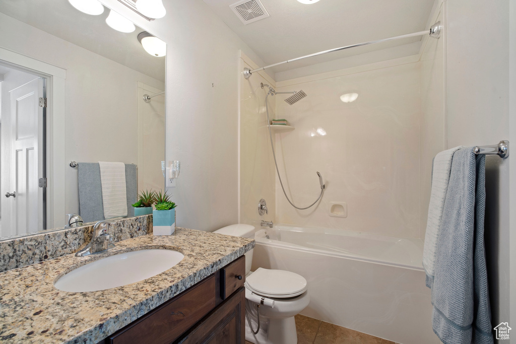 Full bathroom with tile flooring, vanity, toilet, and  shower combination