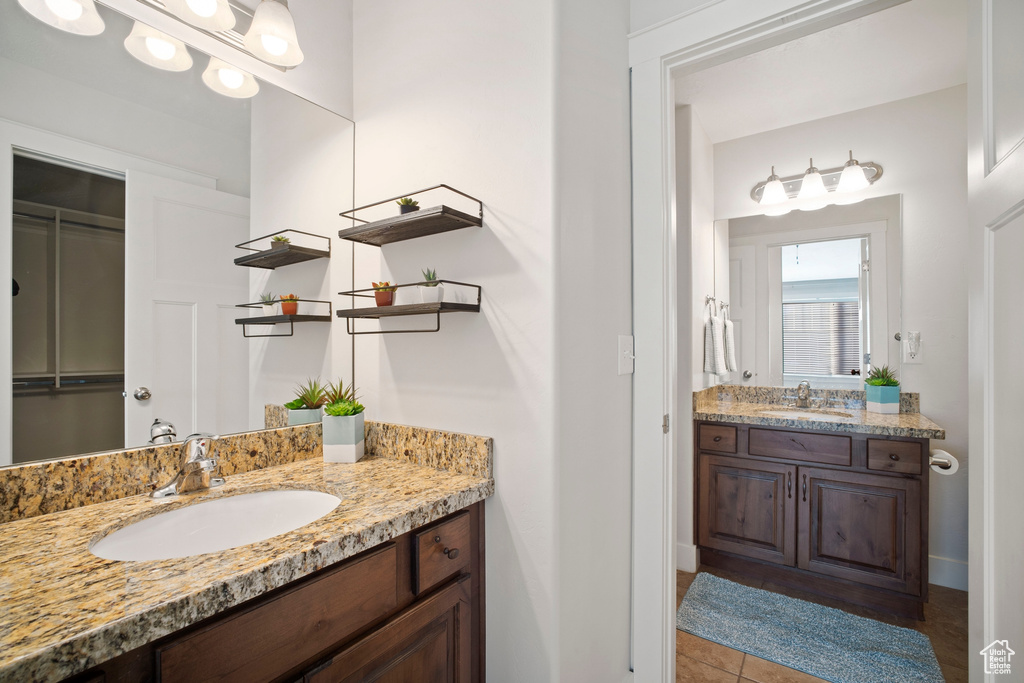 Bathroom featuring dual sinks, tile floors, and large vanity