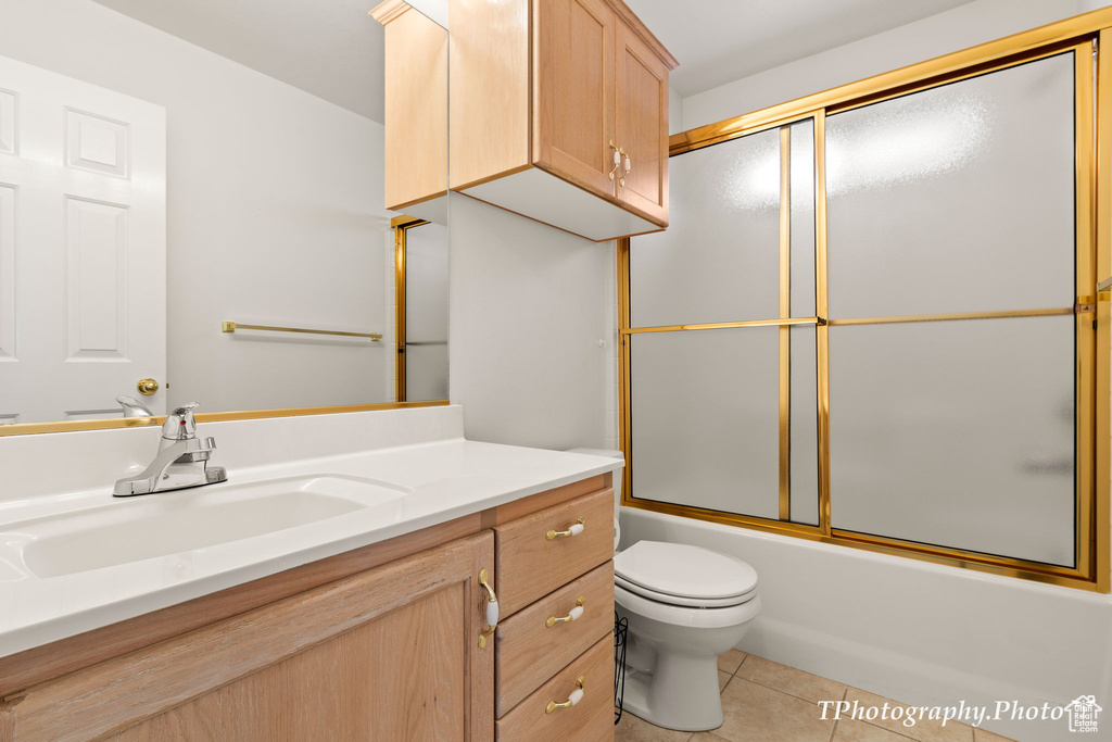 Full bathroom with shower / bath combination with glass door, toilet, tile flooring, and oversized vanity